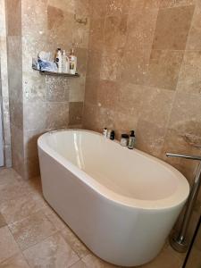 a white bath tub in a bathroom with tiles at Darling Point with Harbour Views in Sydney