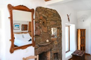 a bedroom with a stone fireplace and a mirror at ⋆ 5BR Oceanside View Near Lighthouse- Pharos VM ⋆ in Mikonos
