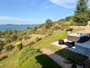 a hot tub on a hill with a view of the water at STONEHOUSE & CASA AL SOLE e AL MARE in Nea Roda
