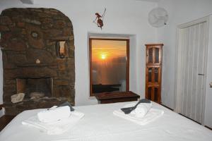 a bedroom with a bed and a stone fireplace at ⋆ 5BR Oceanside View Near Lighthouse- Pharos VM ⋆ in Mikonos
