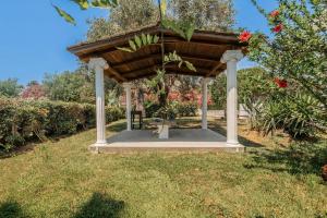 a wooden gazebo in a garden with flowers at Sea View in Laganas