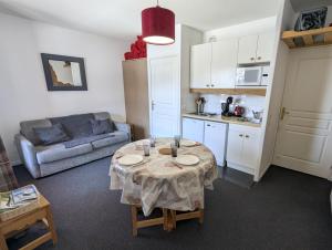 a small living room with a table and a couch at Le Nid Rouge Risoul Balcony & View Ski 100 m in Risoul