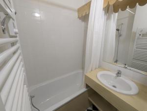 a white bathroom with a sink and a bath tub at Le Nid Rouge Risoul Balcony & View Ski 100 m in Risoul +7 photos