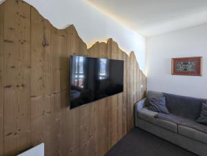 a living room with a flat screen tv on a wooden wall at Le Nid Rouge Risoul Balcony & View Ski 100 m in Risoul