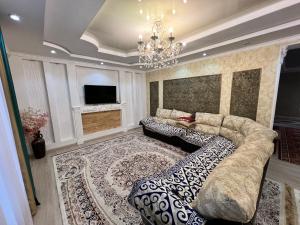a living room with a couch and a tv at Guest house Nuri in Karakol