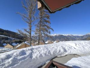 a pile of snow on the roof of a house at Le Nid Rouge Risoul Balcony & View Ski 100 m in Risoul