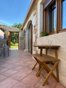 a wooden picnic bench sitting outside of a building at Casal Pedrajás in Muxia