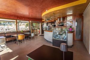 a restaurant with a bar with tables and chairs at Ambienthotel Spiaggia in Malcesine