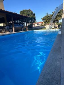a swimming pool with a fountain in a house at Casarão entre Cabo Frio e Búzios Piscina Privativa Ar condicionado, Sinuca, Totó, Churrasqueira 4 quartos Wi-Fi 500mb in Cabo Frio +46 photos