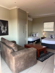 a living room with a couch and two beds at Wonderwerk cave adventures in Kuruman