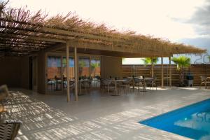 a patio with tables and chairs next to a swimming pool at MONO ALEX Afitos in Afitos