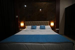 a bedroom with a large bed with blue pillows at Sandy Resort in Agastīswaram