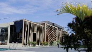 a rendering of a building with a palm tree in front at Sandy Resort in Agastīswaram