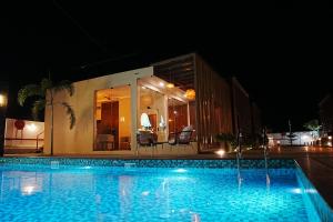 a swimming pool in front of a building at night at Sandy Resort in Agastīswaram +8 photos