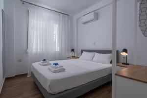 a bedroom with a white bed with towels on it at SLV Irida Apartment in Ofrínion