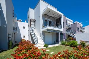 a white house with stairs and a yard at SLV Irida Apartment in Ofrínion