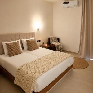 a bedroom with a large white bed and a chair at Hôtel Archipel in Monastir +42 photos
