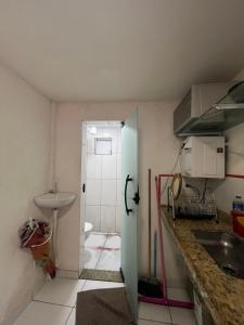 a kitchen with a sink and a door to a bathroom at Loft Aloha in Cabo Frio