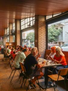 a group of people sitting at tables in a restaurant at Athens Studios in Athens