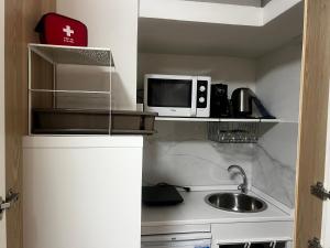a small kitchen with a sink and a microwave at Studio Naty in Marina di Massa