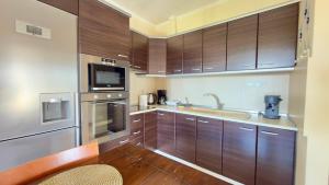 a kitchen with wooden cabinets and a sink at Casa De Sol by Horizon Homes in Ofrínion
