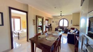 a dining room with a table and a living room at Casa De Sol by Horizon Homes in Ofrínion
