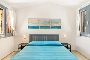 a bedroom with a bed and two windows at Sabbiamare Torre dei Corsari in Torre Dei Corsari