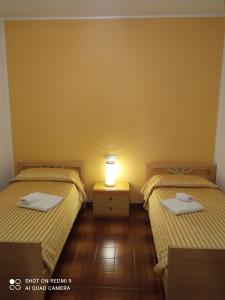 a room with two beds and a lamp on a table at Appartamento al mare in Eraclea Mare