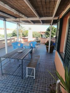 a patio with a table and chairs on a roof at L'attico di Giorgio in Samatzai