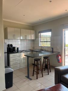 a kitchen with a table and two bar stools at Wonderwerk cave adventures in Kuruman