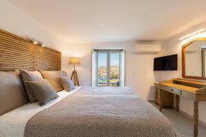 a bedroom with a bed with a desk and a mirror at Villa Sun Sky in Aggelika +67 photos