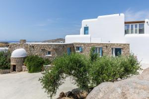 a house on the beach with a rock at Villa Sun Sky in Aggelika
