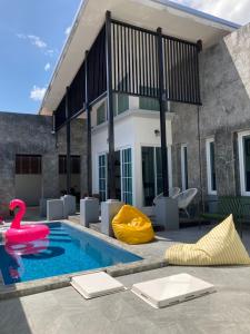 a swimming pool with a pink swan and a yellow float at Nadda Pool Villa Ranong in Ban Bang Rin (1)