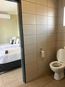 a bathroom with a toilet and a bed in a room at Wonderwerk cave adventures in Kuruman