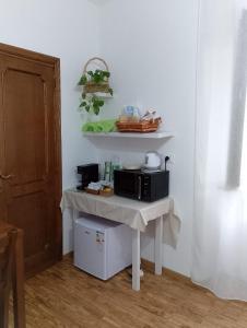 a kitchen with a table with a microwave on it at dalla CARLA in Toscana in Monte San Savino