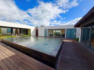 an infinity pool in a house with a wooden deck at Asmara Residence 2 Bedroom Apartment by LOV Mauritius, Beach Access in Petite Case Noyale