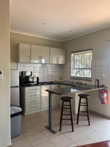 a kitchen with a table and two bar stools at Wonderwerk cave adventures in Kuruman +26 photos