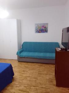 a living room with a blue couch in a room at dalla CARLA in Toscana in Monte San Savino