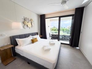 a bedroom with a large bed with a large window at Asmara Residence 2 Bedroom Apartment by LOV Mauritius, Beach Access in Petite Case Noyale +7 photos
