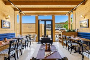a restaurant with tables and chairs and large windows at Dokia Boutique in Gura Humorului