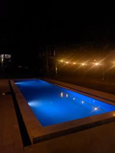 a blue swimming pool at night with lights at Melati resort kuta lombok in Kuta Lombok