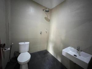 a bathroom with a white toilet and a sink at Melati resort kuta lombok in Kuta Lombok +6 photos