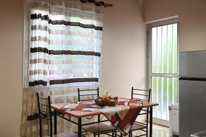 a table and chairs in a kitchen with a table and a window at BotaniCasa by WENS in Preveza
