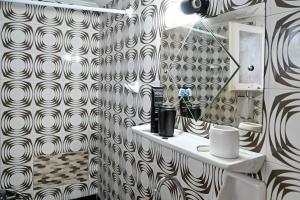 a bathroom with a black and white patterned wall at BotaniCasa by WENS in Preveza
