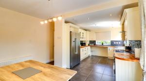 a kitchen with a wooden table and a refrigerator at Spacious and Modern Durham home in Gilesgate +17 photos