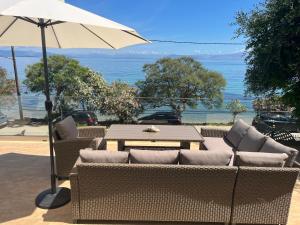 a patio with a table and an umbrella at Boukari Blu Studio Boukari Beach in Boukari