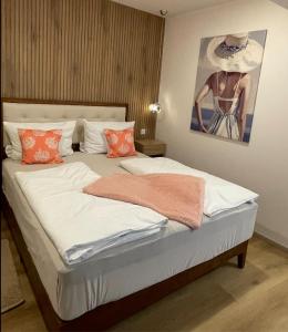 a bed with orange pillows and a painting on the wall at Ferienwohnung am Entenplatz in Eltville