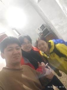 three people posing for a picture with a parrot at Karakol City Center in Karakol