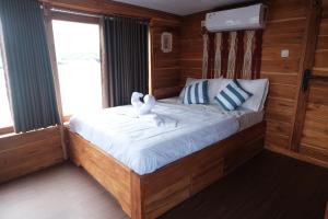 a bedroom with a bed with two stuffed animals on it at Phinisi Private trip Komodo Island in Komodo Labuan Bajo Airport