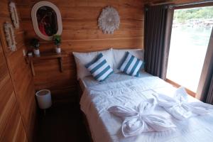 a bedroom with a white bed with blue and white pillows at Phinisi Private trip Komodo Island in Komodo Labuan Bajo Airport